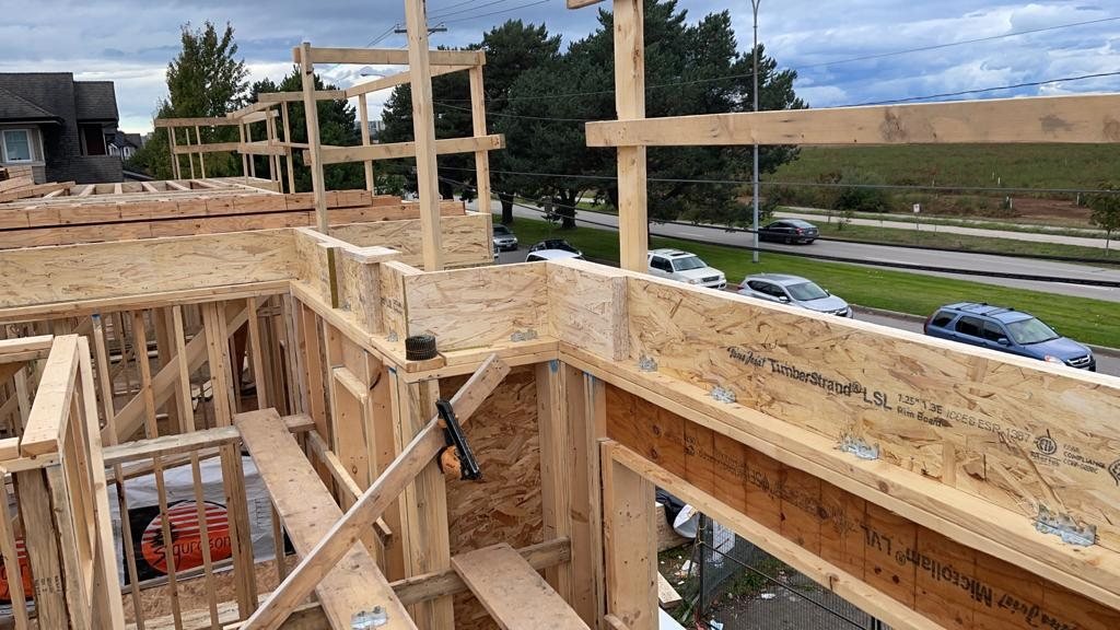 Wood-framed floor edge showing joists, wall studs and an engineered rim board.