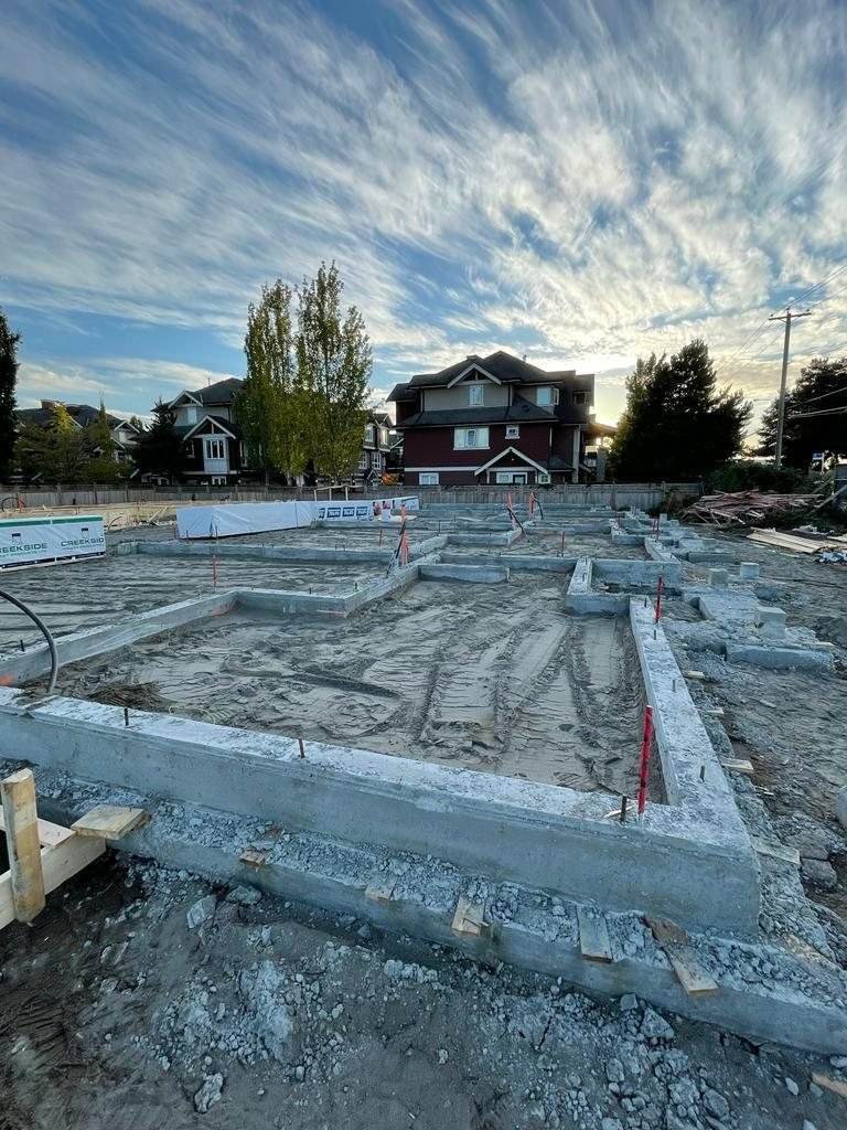 Timber formwork outlines foundation sections across an excavated construction site.