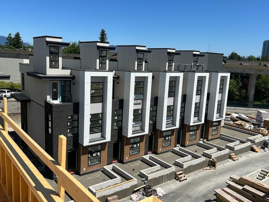 Elevated view of a row of attached homes with finished exterior walls and pitched roofs.