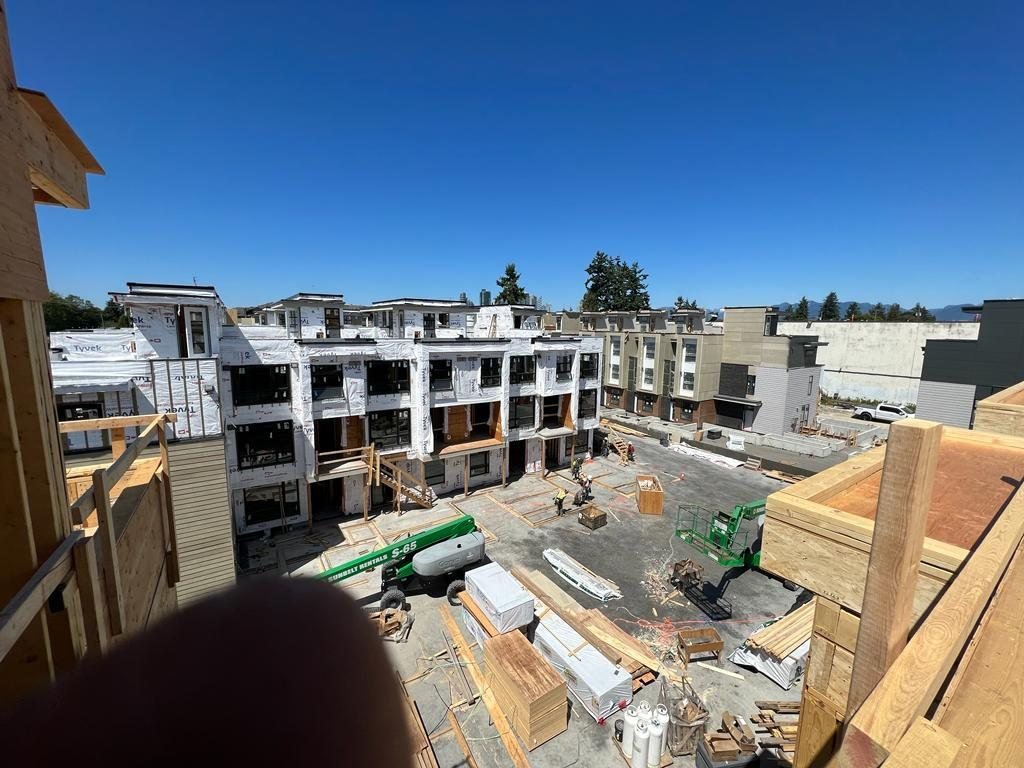 Elevated view across several wood-framed buildings and active work areas.
