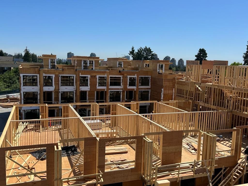 Wood-framed walls and floor edges viewed from inside a multi-unit building.