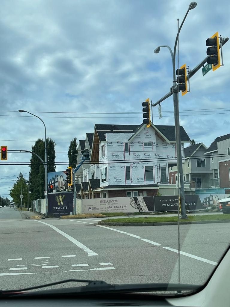 Attached homes and a construction area viewed across a street with utility lines overhead.