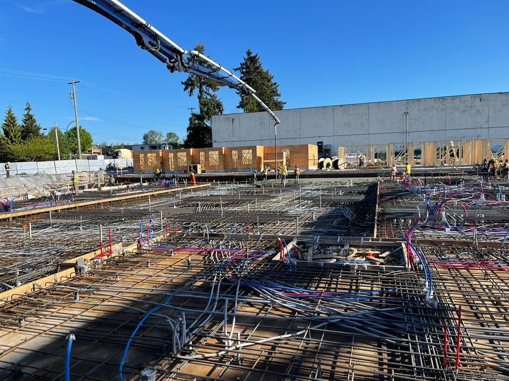 Reinforcing steel and coloured service lines arranged across a large slab area.