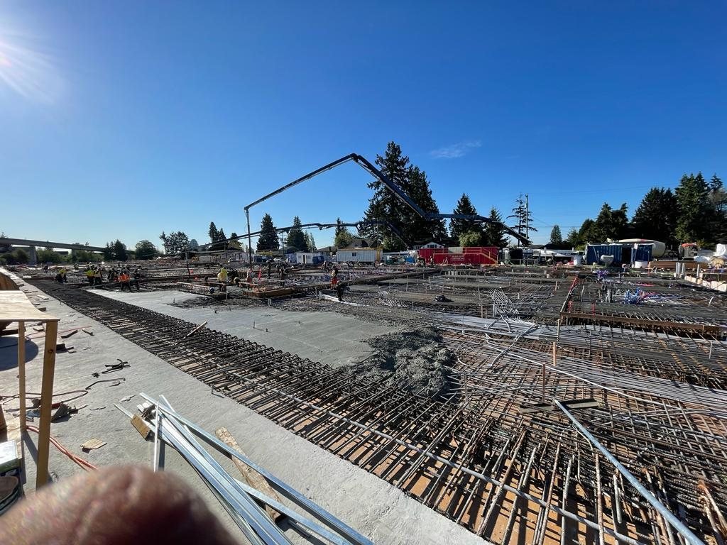 Dense reinforcing steel and service lines across a concrete slab before placement.