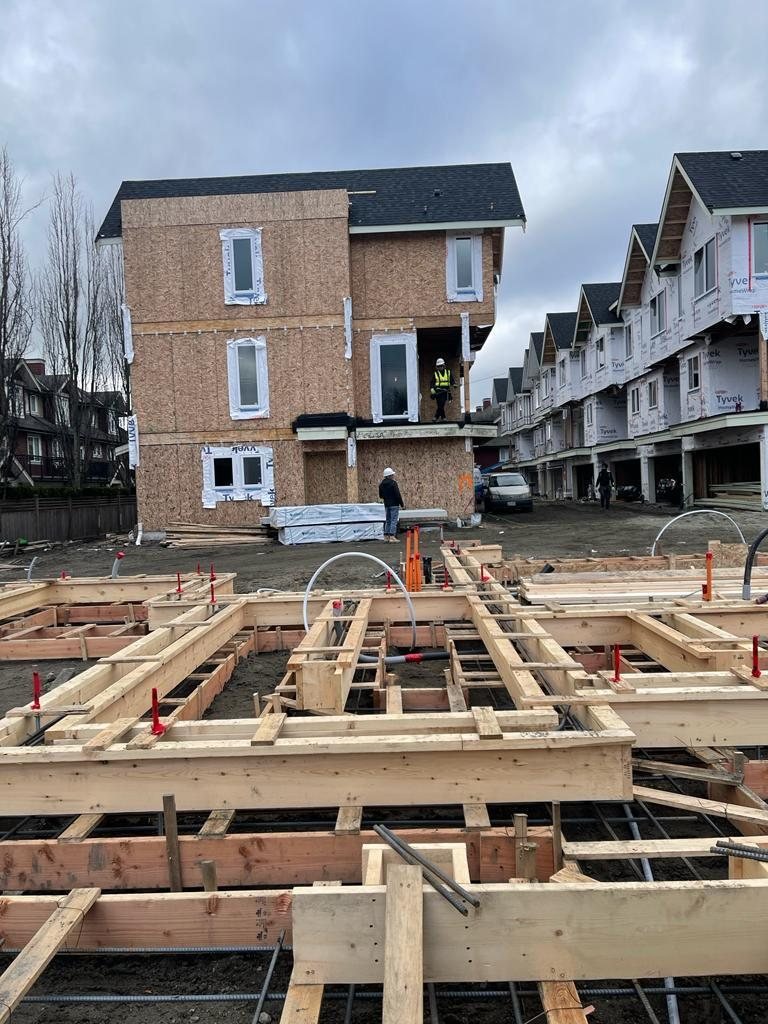 Wood floor joists and beams connecting framed residential building sections.