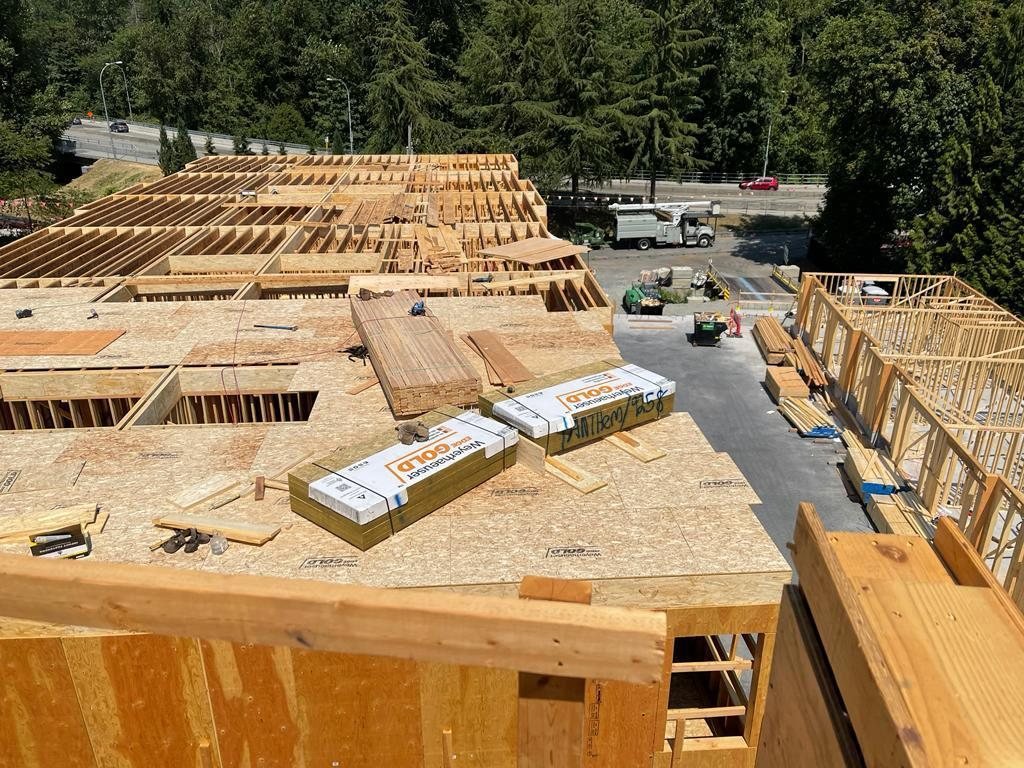 Wood framing members and sheathing panels staged on an elevated floor.