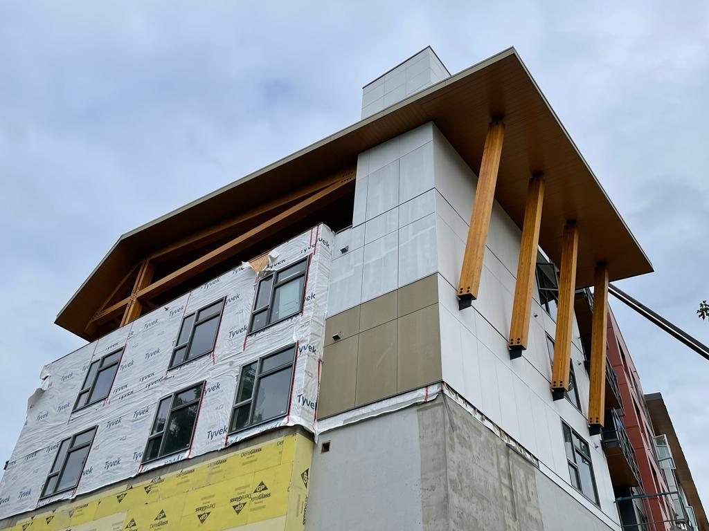 Projecting timber canopy and balcony details on a multi-storey residential building.