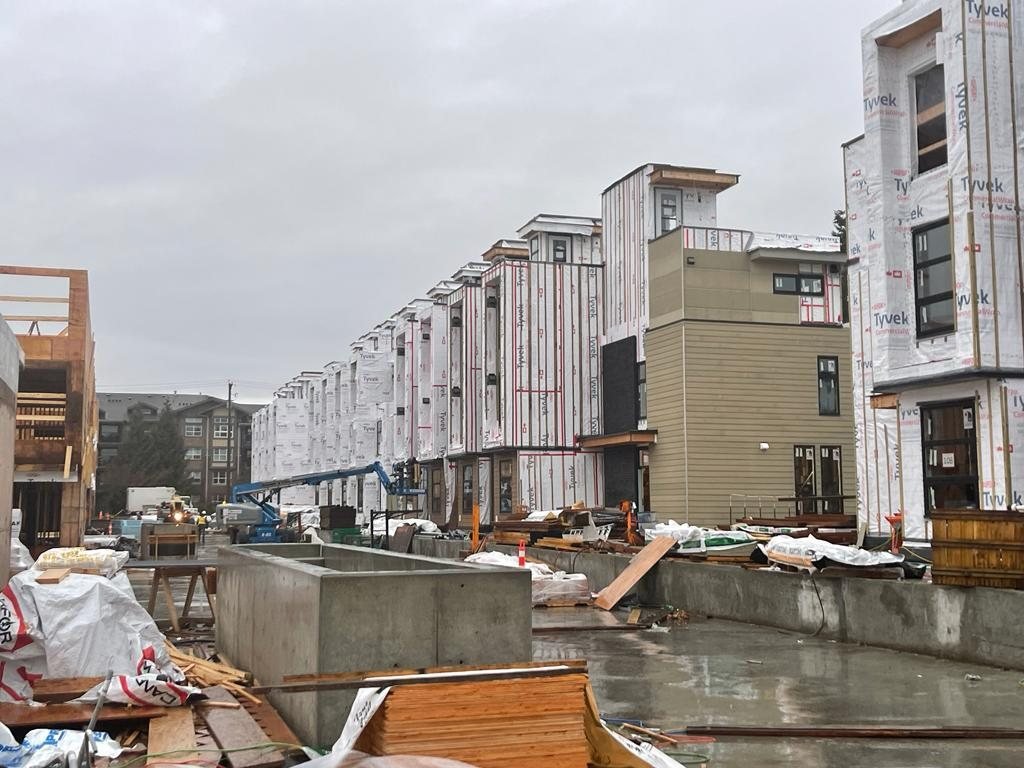Multi-storey residential buildings with weather barrier and a wet active work area.