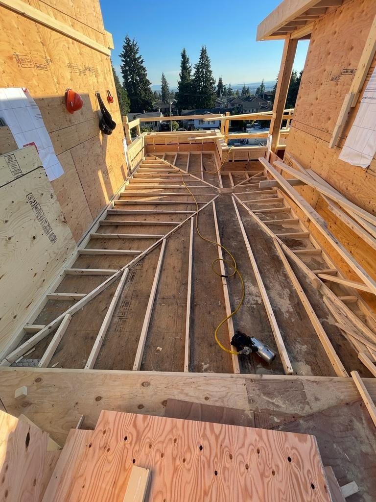 Wood floor framing around an opening with service lines visible between members.